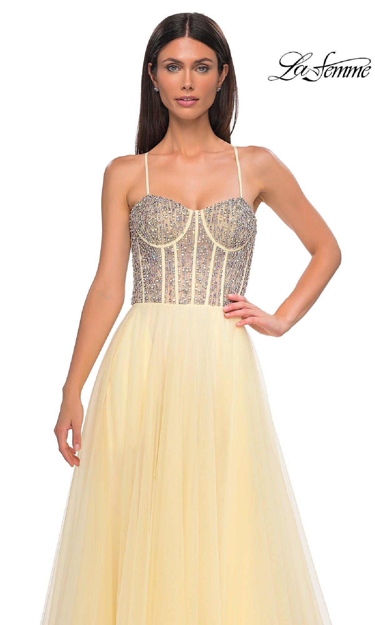 A woman models the La Femme 32703 Beaded-Corset Long Prom Dress in pale yellow, featuring a rhinestone-beaded corset bodice with thin straps, shown against a plain white background.
